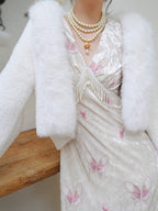 Inspired by the ethereal texture of cloud mousse, this wrap embodies luxurious comfort. Crafted from incredibly soft, plush faux mink fur, it offers a guilt-free, vegan-friendly opulence. The pure white hue and elegant shawl collar design evoke timeless French elegance. Lightweight yet cozy, it's the perfect statement piece for effortless style and sublime warmth, blending ethical fashion with a touch of romantic sophistication.