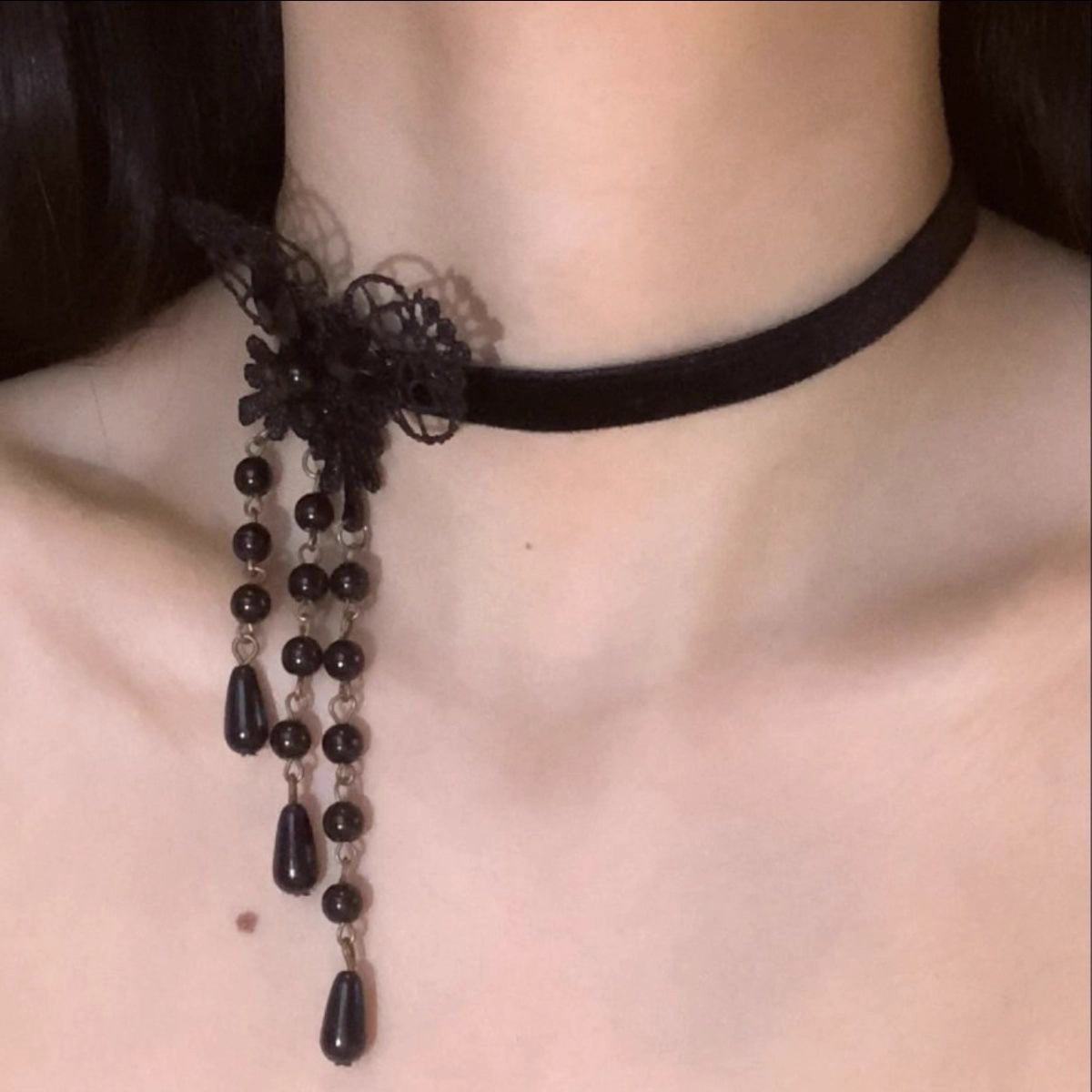 This Lolita Gothic Choker Necklace blends elegance with a dark romantic charm. Crafted from delicate black lace, it features a butterfly centerpiece adorned with pearls and flowing tassels, creating a graceful layered look. Designed to highlight the collarbone, it adds both mystery and sophistication to any outfit. Perfect for gothic Lolita ensembles, parties, or special occasions, this accessory is a refined statement piece that enhances the allure of classic dark Lolita style.
