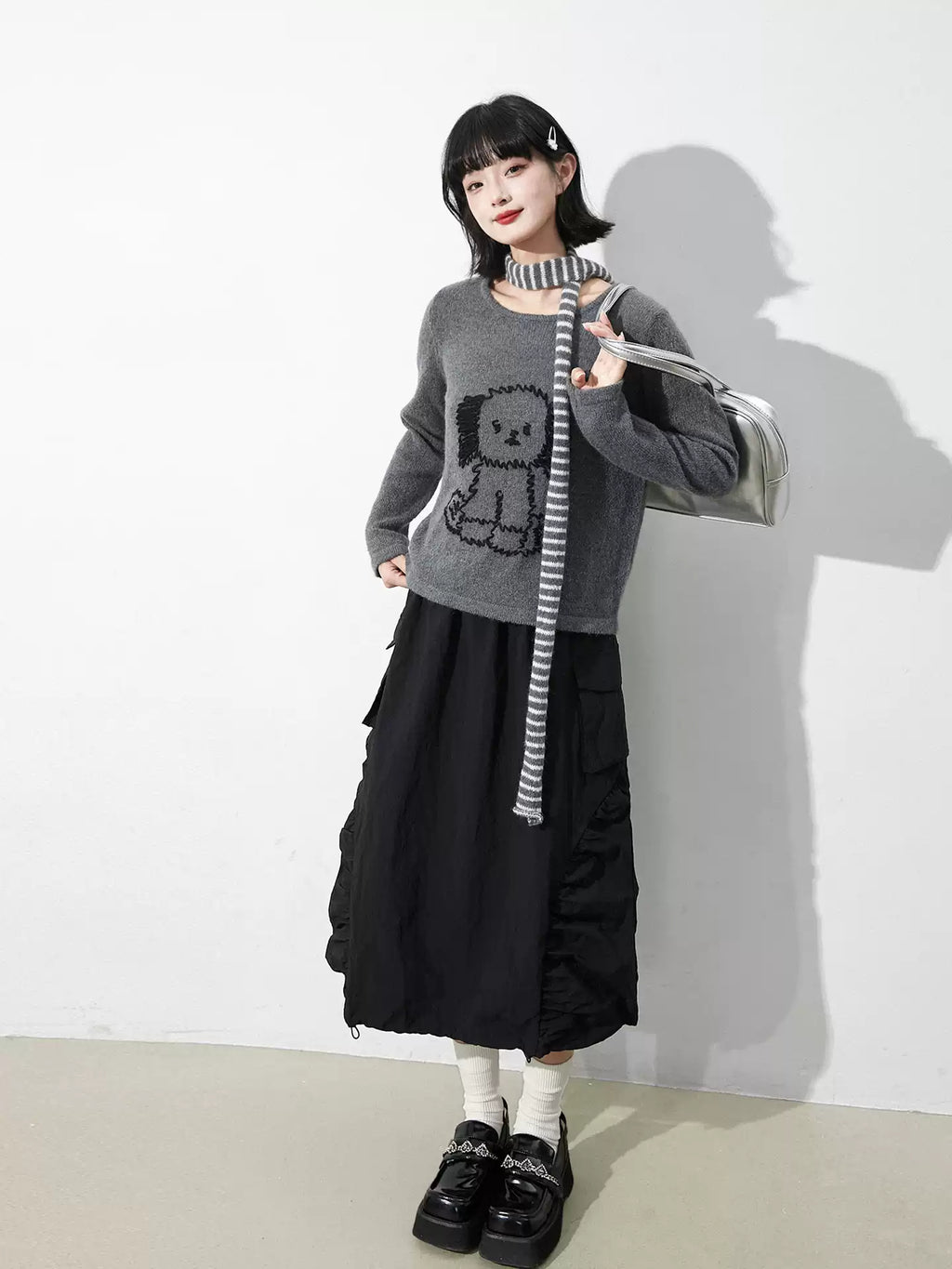 This skirt blends edgy charm with playful sweetness through its functional drawstring detail and sharp A-line silhouette. The adjustable waist and strategic pleating create a flattering, customized fit. Designed in versatile black, it balances minimalist structure with youthful rebellion, offering a statement piece that effortlessly transitions from casual daytime wear to bold nighttime street style.