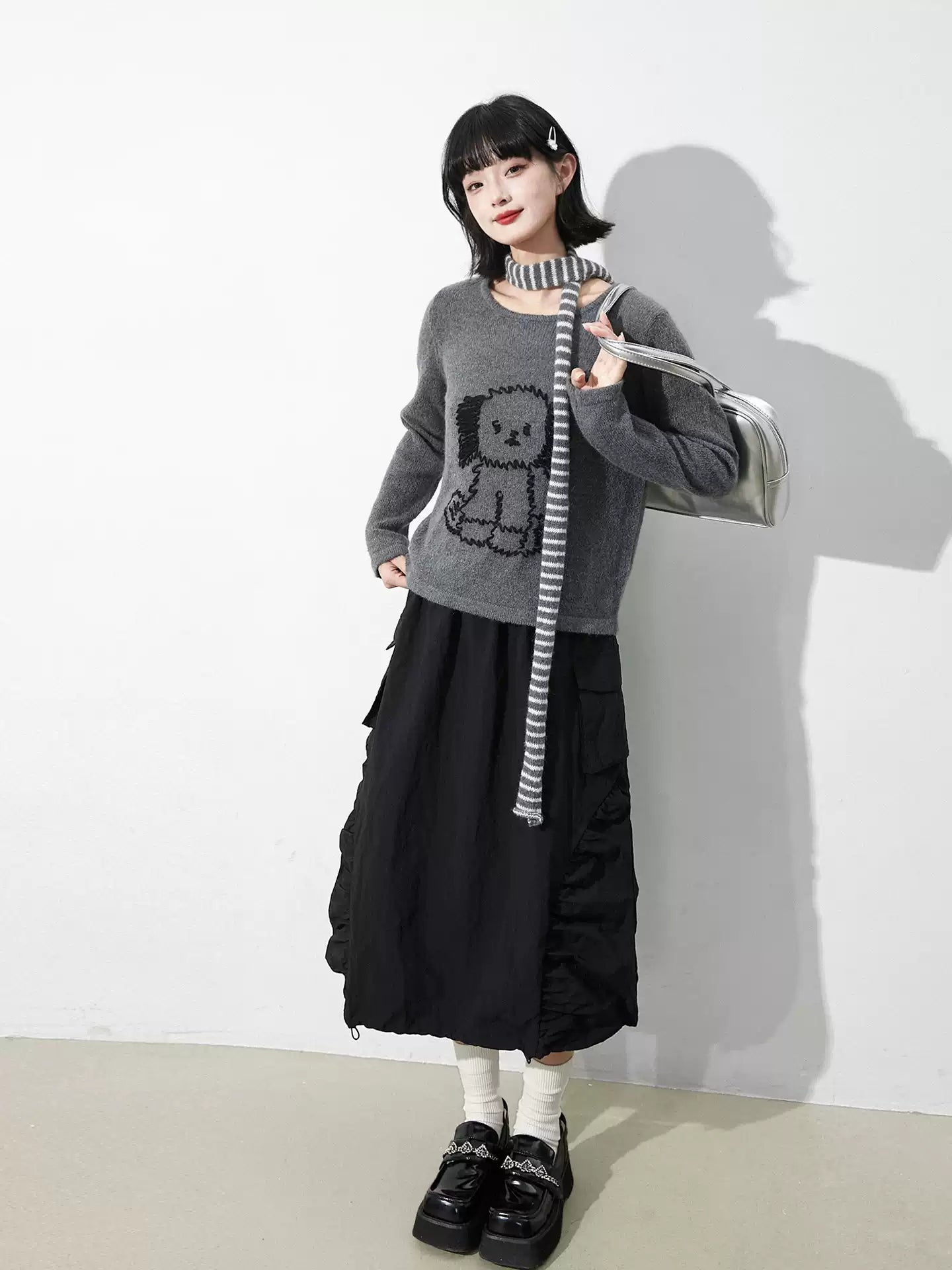 This skirt blends edgy charm with playful sweetness through its functional drawstring detail and sharp A-line silhouette. The adjustable waist and strategic pleating create a flattering, customized fit. Designed in versatile black, it balances minimalist structure with youthful rebellion, offering a statement piece that effortlessly transitions from casual daytime wear to bold nighttime street style.