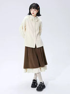 This skirt blends vintage charm with modern elegance. The high-waisted A-line silhouette and delicate pleats gracefully conceal hips and elongate the figure. A soft flounce hem adds a touch of romantic movement. Crafted from warm wool blend fabric, it's designed for both comfort and style, offering a timeless piece that transitions seamlessly from casual daytime outings to refined autumn evenings.