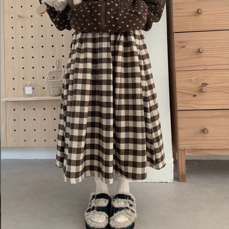 Inspired by cozy autumn days, this Chestnut skirt features an original plaid pattern in rich brown and coffee tones. Designed with a classic A-line silhouette, it effortlessly skims the body for a flattering, timeless look. Crafted from a warm and textured wool-blend fabric, it combines vintage charm with modern comfort. This versatile piece is created to be a staple in your winter wardrobe, perfect for adding a touch of rustic, intellectual elegance to any casual outing.