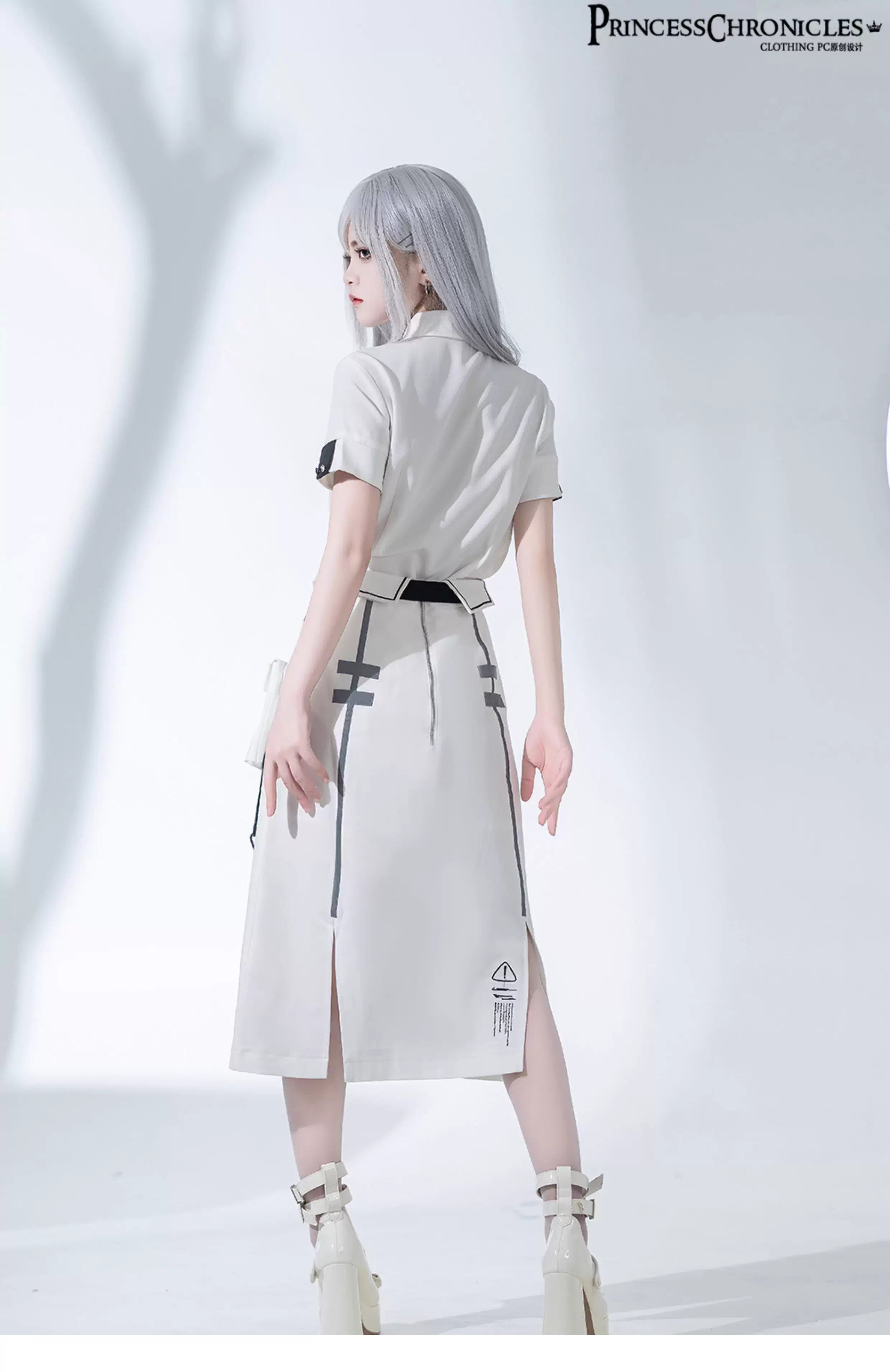 Blending Lolita’s delicate silhouette with techwear’s utilitarian edge, this skirt features asymmetric layered tiers, modular attachment points, and hidden pockets. The crisp white fabric contrasts with tactical straps and geometric seams, creating a fusion of poetic softness and cyberpunk functionality. Designed for dynamic movement and layered styling, it embodies a future where elegance meets rebellion.