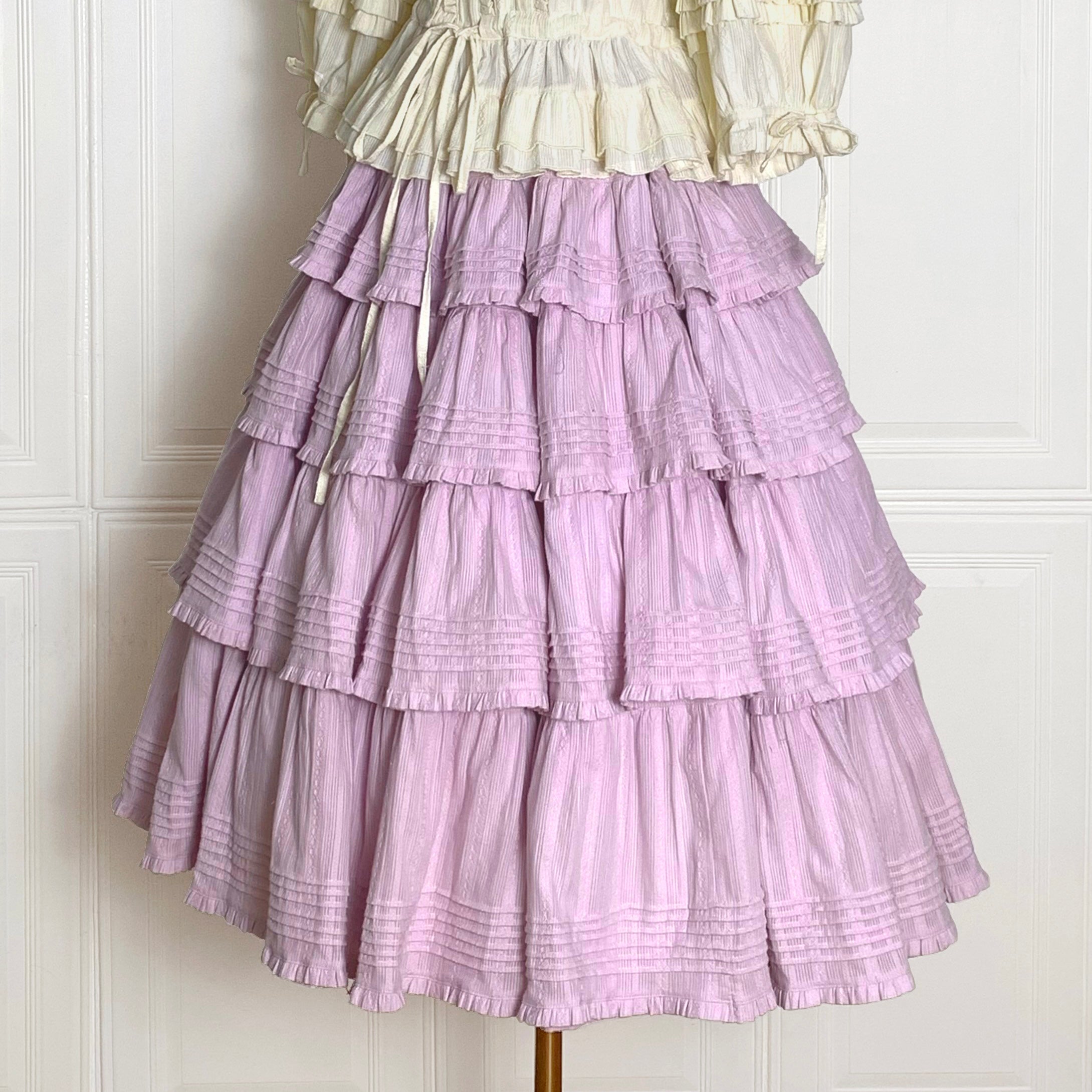 Embrace rustic charm with this Heidi-inspired cottagecore Lolita skirt, crafted from premium heavy cotton for structured elegance. Meticulous embroidery and delicate trims adorn its flowing silhouette, echoing the whimsy of alpine meadows and storybook dreams. Designed for layering or standalone wear, this skirt offers versatility and timeless appeal. Available in multiple nature-inspired hues, it effortlessly complements blouses or JSKs for a pastoral yet polished coordinate. Perfect for tea parties, garde