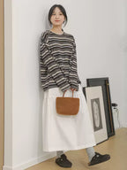 The Muse Society A-line skirt combines minimalist elegance with thoughtful design. The high-waisted cut and strategic pleating work to flatter your silhouette, effortlessly smoothing the waist and hips for a slimming effect. Crafted from a soft, breathable cotton-blend fabric, it ensures all-day comfort. This versatile skirt is designed to be a timeless, ageless staple in your wardrobe, perfect for creating a chic and polished look that transitions seamlessly across seasons.