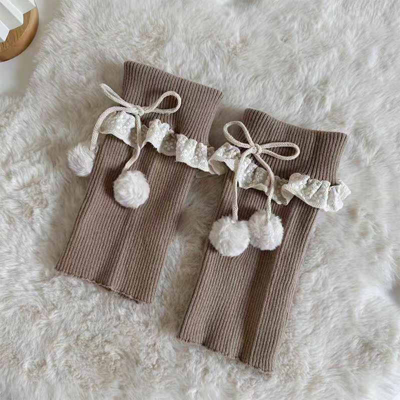 Inspired by the cozy kawaii aesthetics of Japanese street fashion, these knit leg warmers blend playful charm with winter comfort. The delicate lace trim, fluffy pompom details, and soft cream-pink color palette evoke a sweet Lolita vibe. Perfect for layering in fall and winter, they add a touch of dreamy elegance to any outfit while keeping you warm and stylish.