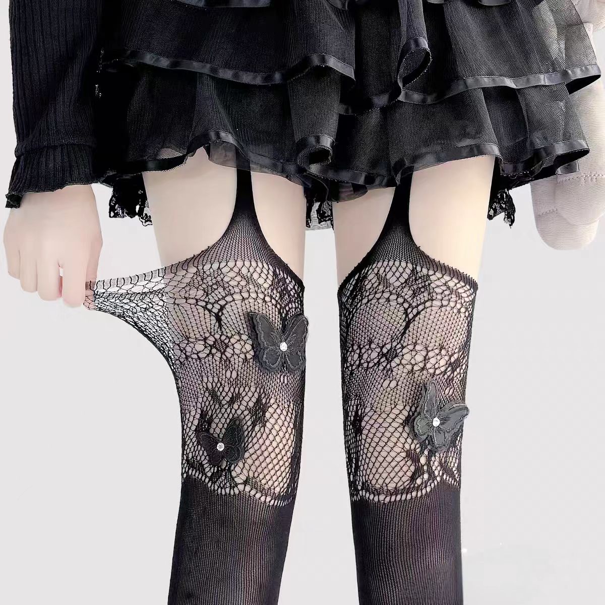 Designed for the bold and glamorous, these fishnet tights redefine edgy elegance. Delicate butterfly motifs adorned with sparkling rhinestones create a striking contrast against the sheer net fabric. The intricate strappy design and lace detailing add a touch of provocative sophistication, perfect for making a statement night out or elevating any daring fashion ensemble. Confidence woven into every thread.