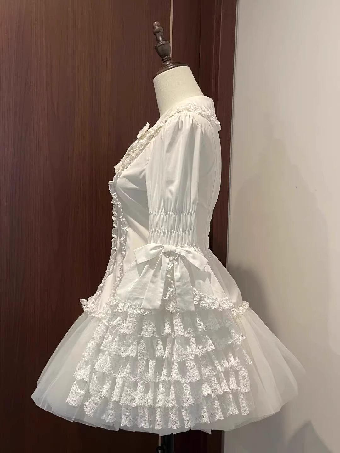 Inspired by antique porcelain dolls and Victorian elegance, this blouse features dramatic gigot sleeves, delicate lace trim, and a tailored yet forgiving fit. The ivory and black color options evoke timeless sophistication, while lightweight fabric ensures comfort. Designed to layer under jumperskirts or wear standalone, it celebrates opulent nostalgia with modern inclusivity. Perfect for creating a poetic, romantic silhouette.
