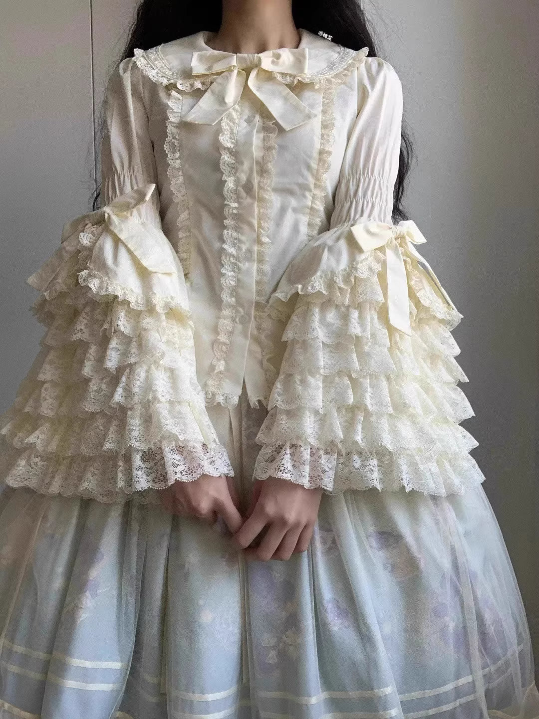 Inspired by antique porcelain dolls and Victorian elegance, this blouse features dramatic gigot sleeves, delicate lace trim, and a tailored yet forgiving fit. The ivory and black color options evoke timeless sophistication, while lightweight fabric ensures comfort. Designed to layer under jumperskirts or wear standalone, it celebrates opulent nostalgia with modern inclusivity. Perfect for creating a poetic, romantic silhouette.