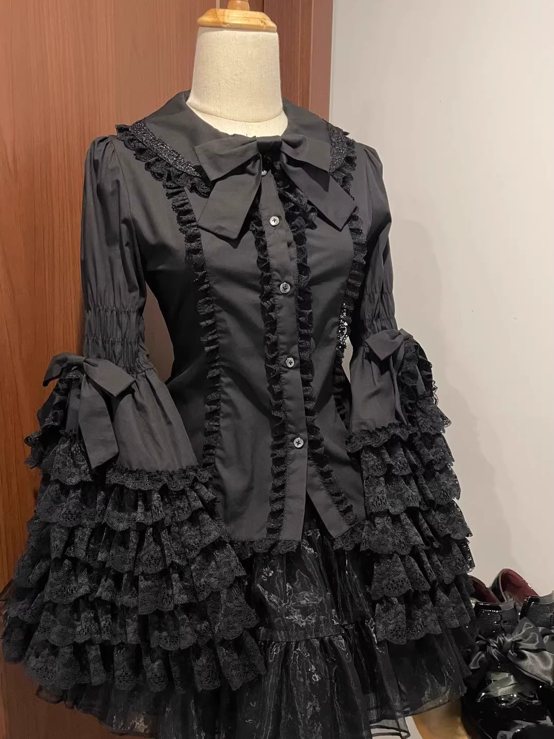 Inspired by antique porcelain dolls and Victorian elegance, this blouse features dramatic gigot sleeves, delicate lace trim, and a tailored yet forgiving fit. The ivory and black color options evoke timeless sophistication, while lightweight fabric ensures comfort. Designed to layer under jumperskirts or wear standalone, it celebrates opulent nostalgia with modern inclusivity. Perfect for creating a poetic, romantic silhouette.