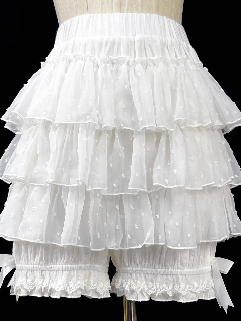 These delicate safety shorts combine functionality with Lolita aesthetics. Featuring lace-trimmed tiers and a bloomer-inspired design, they provide discreet coverage under skirts and dresses. Rendered in classic black and white, the lightweight fabric ensures comfort while adding a romantic touch to any coordination. Perfect for both sweet and Gothic styles, they offer practical elegance for dynamic wear.