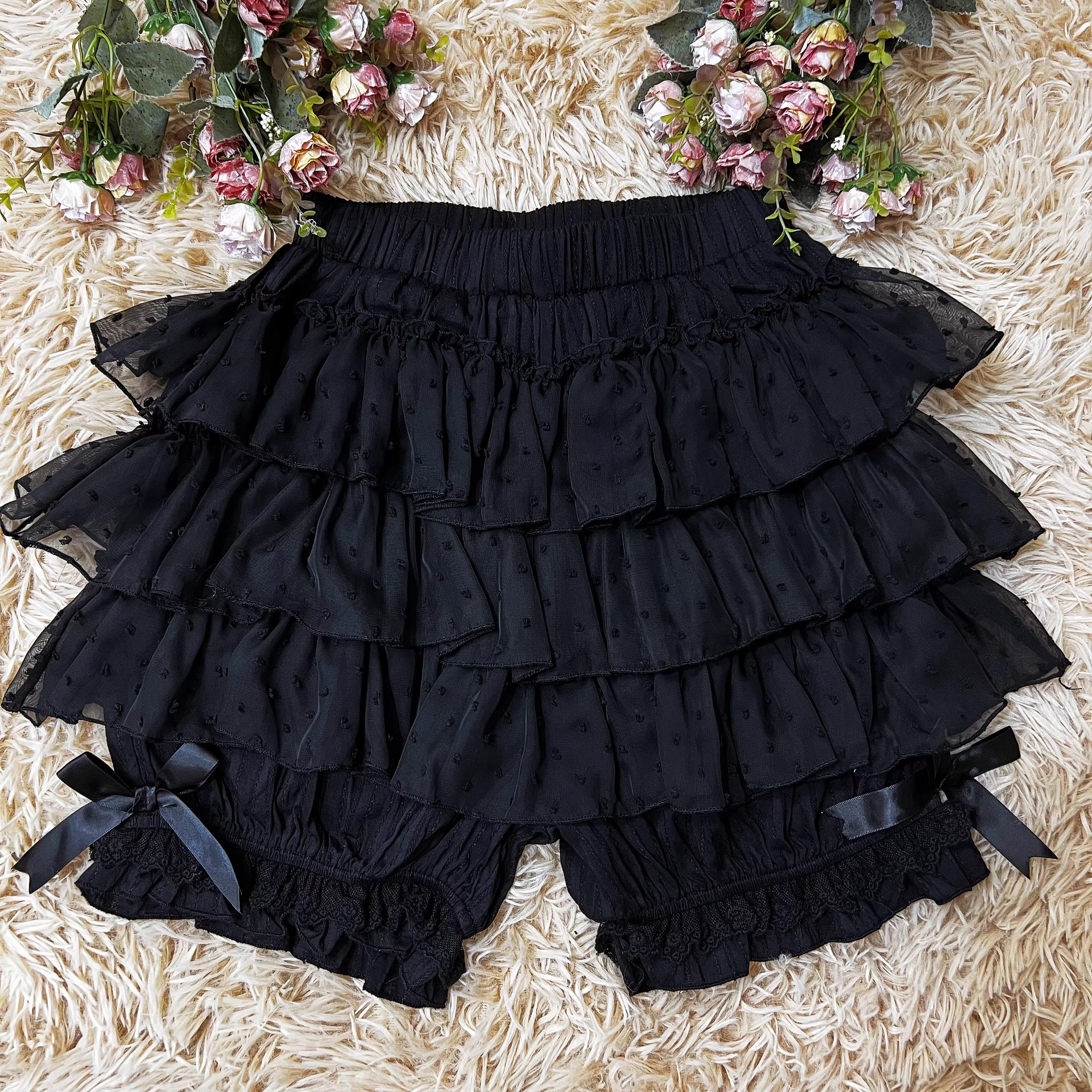These delicate safety shorts combine functionality with Lolita aesthetics. Featuring lace-trimmed tiers and a bloomer-inspired design, they provide discreet coverage under skirts and dresses. Rendered in classic black and white, the lightweight fabric ensures comfort while adding a romantic touch to any coordination. Perfect for both sweet and Gothic styles, they offer practical elegance for dynamic wear.