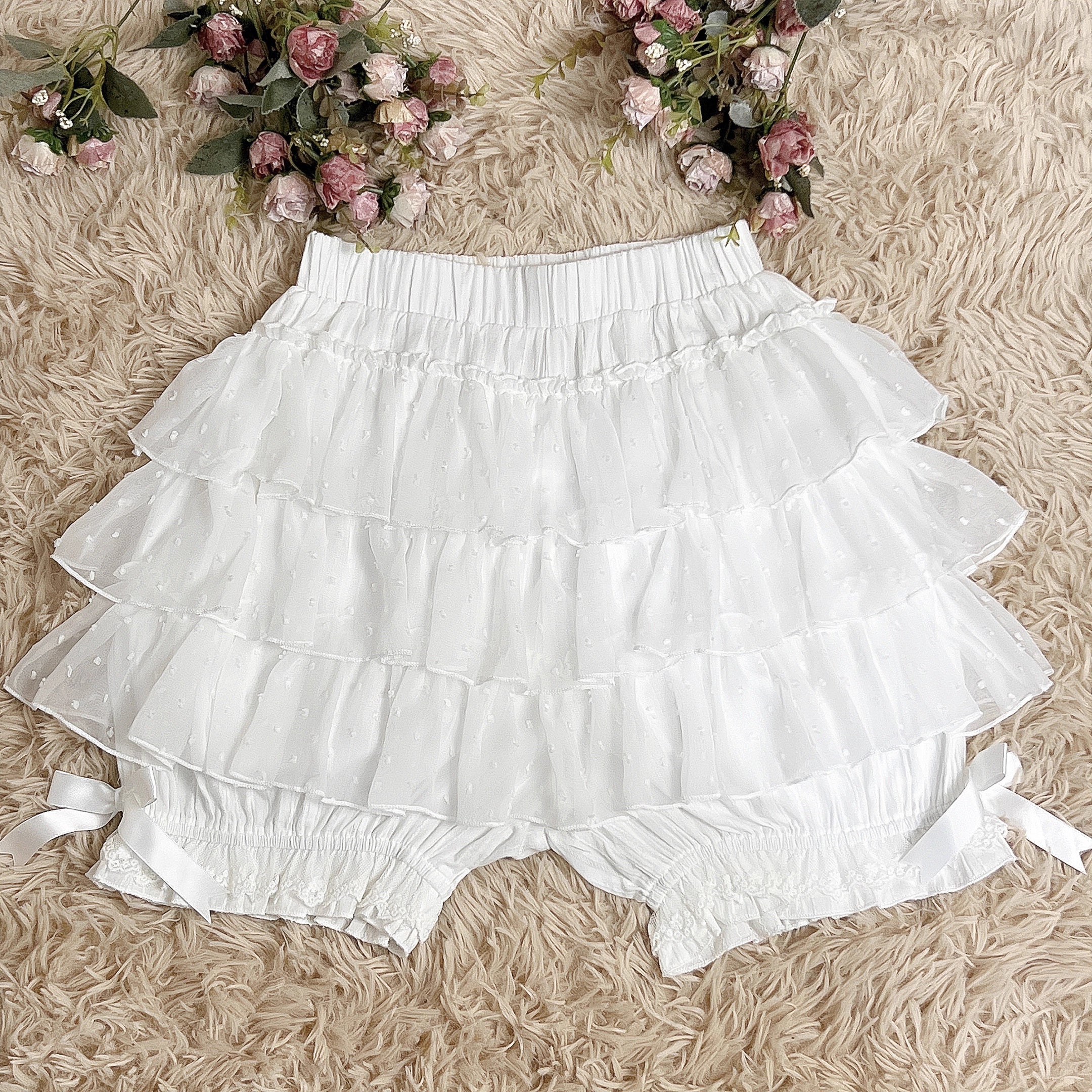 These delicate safety shorts combine functionality with Lolita aesthetics. Featuring lace-trimmed tiers and a bloomer-inspired design, they provide discreet coverage under skirts and dresses. Rendered in classic black and white, the lightweight fabric ensures comfort while adding a romantic touch to any coordination. Perfect for both sweet and Gothic styles, they offer practical elegance for dynamic wear.