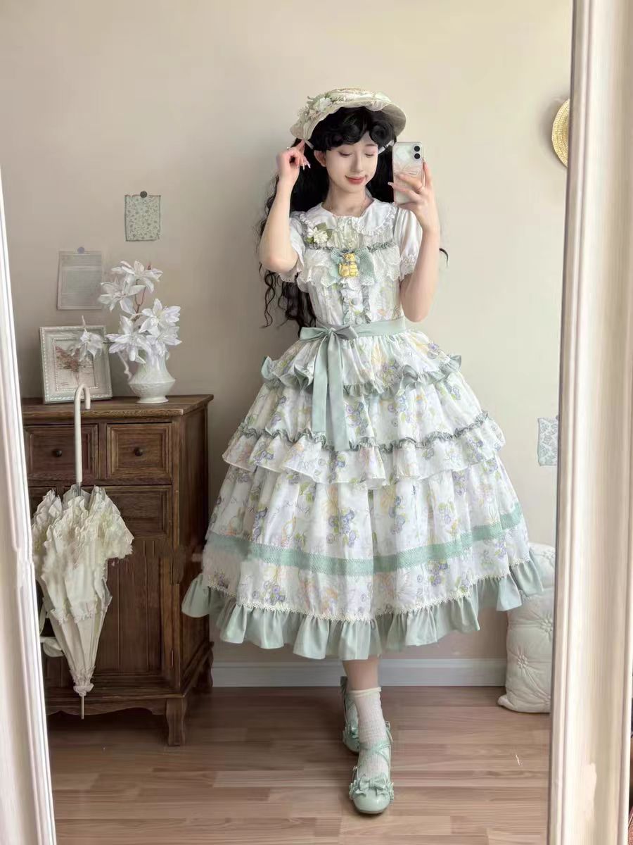 This Purple Green Classic Sweet Lolita JSK Dress is crafted to blend elegance with playful charm. The sleeveless design highlights the triple-layered ruffles and soft lace details, creating a light yet voluminous silhouette. Bowknot accents add a touch of sweetness, while the purple and green color combination offers a refreshing and unique vintage feel. Perfect for tea parties, daily outings, or themed events, this dress reflects timeless Lolita grace with a colorful twist.