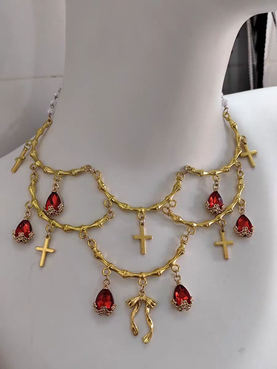 This Lolita Gold Layered Necklace embodies luxurious vintage elegance with a touch of European palace charm. Featuring multiple delicate layers, intricate cross details, and a refined gold finish, it highlights the neckline with sophistication. Perfect for tea parties, cosplay, or formal Lolita gatherings, this accessory enhances any classic or elegant outfit. Its ornate design blends traditional Gothic influences with regal Lolita aesthetics, creating a statement piece that exudes refinement and charm.