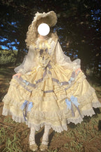 "Inspired by the opulence of royal courts and the delicate beauty of gilded artistry, this dress transforms classic Lolita elegance into a vision of luxury. The gold-toned palette evokes a sense of grandeur, while intricate lace and cascading ruffles reflect both tradition and fantasy."