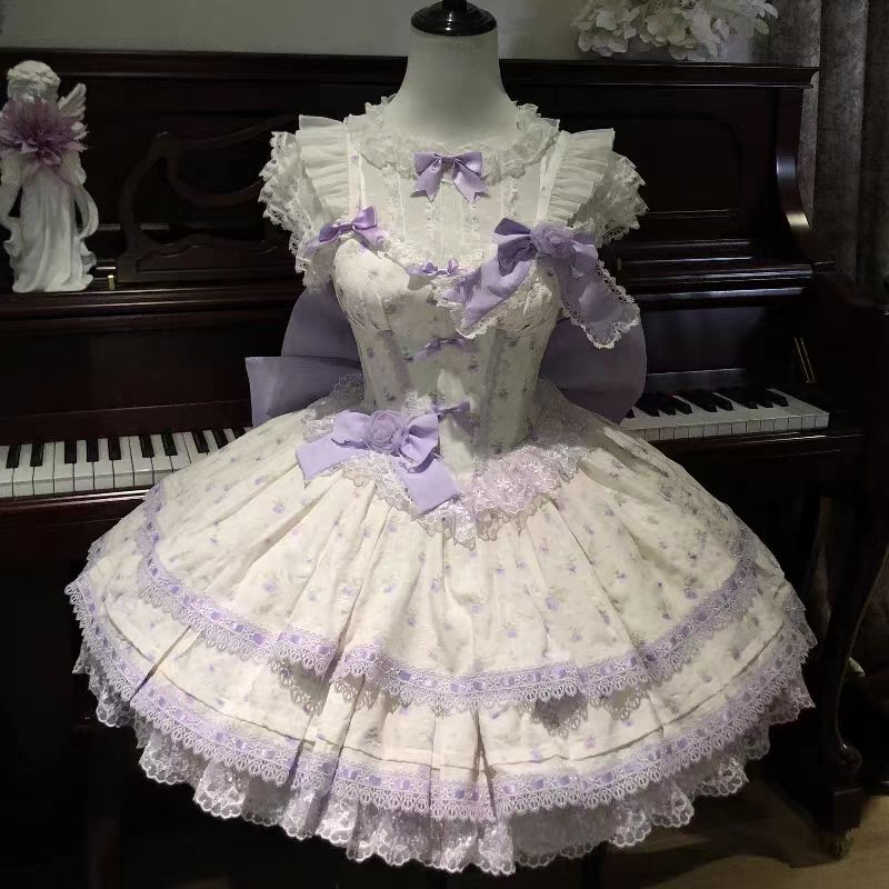 This Sweet Lolita Purple JSK Dress Set combines dreamy elegance with playful sweetness. Designed with multi-layered ruffles, delicate lace, and charming bowknot accents, it creates a voluminous and graceful silhouette. The soft purple hue adds a touch of fairytale romance, while the printed details bring extra charm and individuality. Perfect for tea parties, gatherings, or themed occasions, this dress set highlights the enchanting beauty of Lolita fashion in a refined and versatile style.