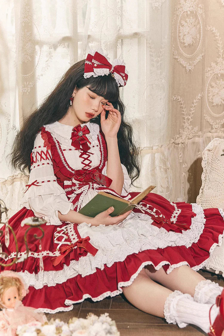 This Red White Sweet Lolita JSK Dress features a charming sleeveless design paired with a delicate cardigan for versatile layering. Multi layered ruffles and lace trims create a soft voluminous silhouette while bowknot details enhance its playful sweetness. The bold red and pure white contrast offers a festive yet elegant look making it perfect for tea parties holiday gatherings or themed occasions. Designed for comfort and style this set captures the essence of youthful Lolita fashion with timeless charm.