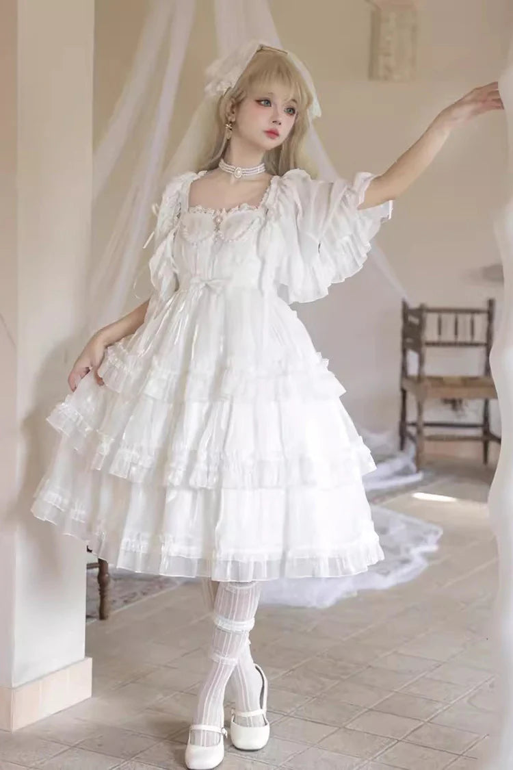 The Wedding Lolita White Starry Romance JSK Dress is created to blend bridal elegance with the dreamy sweetness of Lolita fashion. Crafted in pure white, it features multi-layered ruffles, graceful bow accents, and subtle starry details that evoke a fairytale atmosphere. The princess silhouette conveys both purity and sophistication, making it perfect for special ceremonies, photoshoots, or romantic occasions. Designed to capture timeless beauty, it offers a harmonious balance of sweetness, refinement, and 