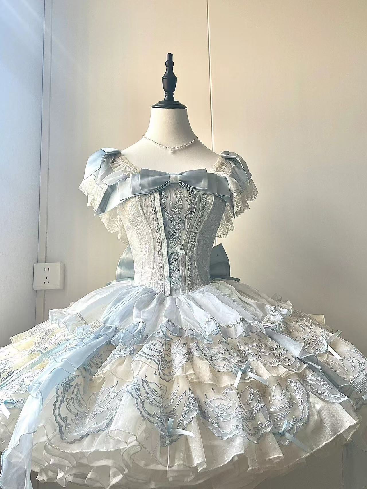 Design Concept:

This exquisite Sweet Lolita dress draws inspiration from classical ballet, featuring a delicate blue color scheme and intricate embroidery that creates an atmosphere of elegant sweetness. The dress comes with a beautifully crafted bow accent on the chest and includes a detachable train, adding a touch of princess-like grandeur to your ensemble. Made from high-quality tulle and cotton fabrics, the full skirt creates a lovely silhouette reminiscent of a ballerina's tutu, while the detailed em